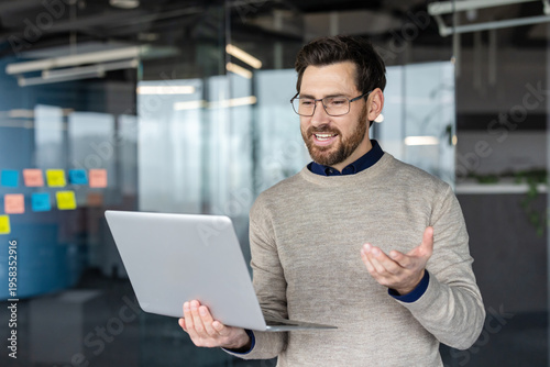 Tableau sur toile Professional man standing in a modern office presenting in a video conference, s