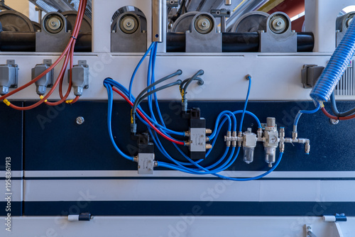 Pneumatic control panel with air pressure regulators and solenoid valves on industrial machine.