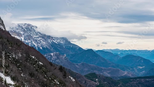 Timelapse of fog forming over mountain ridge and clouds drifting along Vercors slopes from Col du Rousset, France
