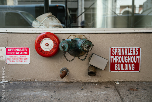 Quadro su tela A red sprinkler fire alarm and standpipe connection are mounted on a building wall in New York City