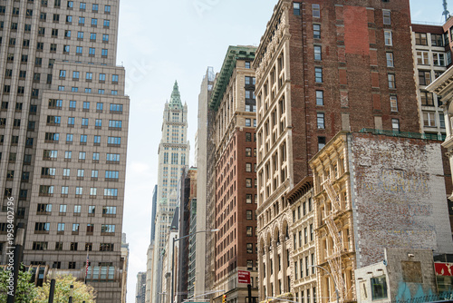 Historic brick and cast iron buildings stand beside modern high rise towers in Manhattan, New York City. The layered architecture reflects the city's rich urban history and development.
