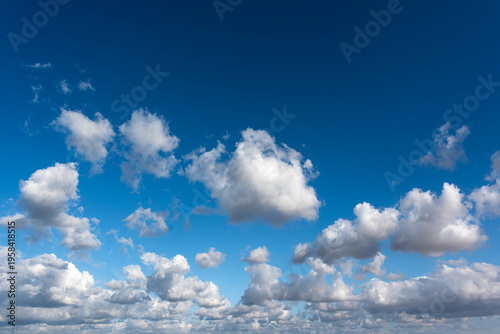 Tablou pe pânză Rows of cottony clouds drifting across the blue sky, spread across the horizon