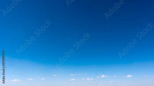 Foto Cottony clouds covering the horizon in the clear blue sky