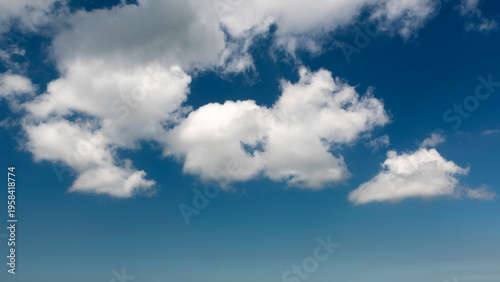 Fotografie white, cottony clouds covering the clear blue sky