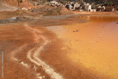 Pit lake with orange hues due to oxidation and mining waste in the mines of Mazarron town