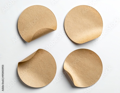 Four brown paper circles, peeled corners, on white