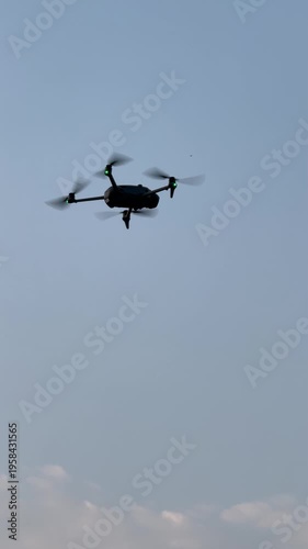 The footage shows a camera drone flying against the clear blue sky.