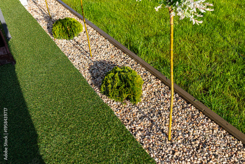 Garden landscaping with gravel band separating grass areas