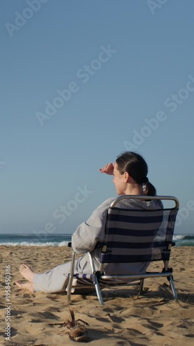 Woman Relaxing on a Beach Chair Looking at the Calm Ocean