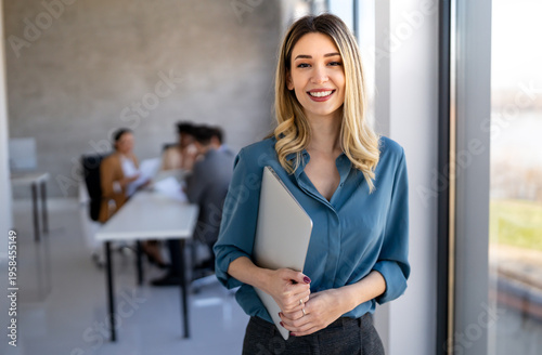 Young happy successful business woman working in corporate office