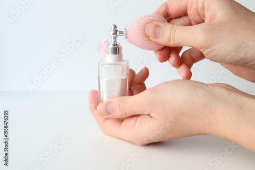 Photo taken in Poland, Krakow, March, a person holding a small perfume bottle with a pump, a glass jar with loose powder, decorative cosmetics, self-care for women,