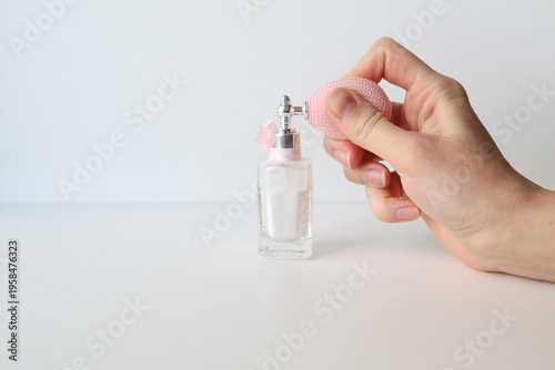 Photo taken in Poland, Krakow, March, a person holding a small perfume bottle with a pump, a glass jar with loose powder, decorative cosmetics, self-care for women,