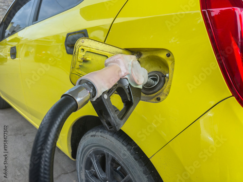 the process of filling a car with fuel using a white pump nozzle, which means using subsidized Pertalite fuel