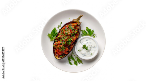 Delicious stuffed eggplant with savory sauce and fresh herbs on a white plate