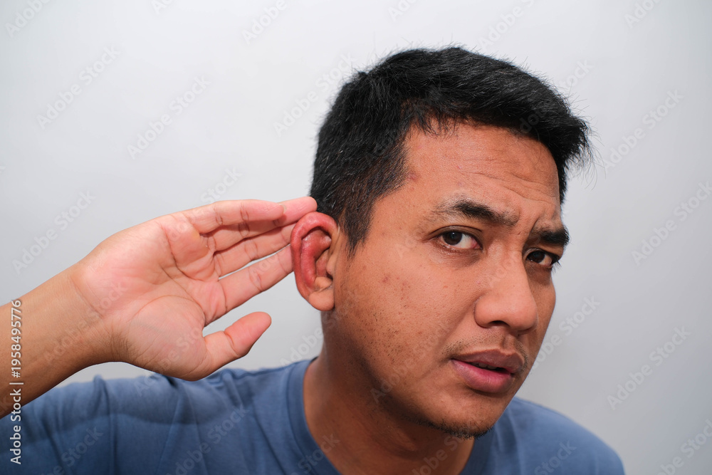 Obraz premium A close-up shot captures a person's ear with a red, swollen area, possibly indicating a skin irritation or infection, as fingers gently touch the lobe.