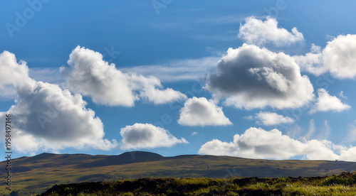 Φωτογραφία Idyllische Hügellandschaft unter einem weiten blauen Himmel mit Schäfchenwolken