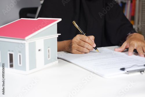 Woman real estate agent or customer signing contract to buy house, insurance or mortgage loan. Rent, buying home, real estate concept
