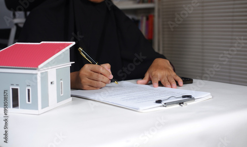 Woman real estate agent or customer signing contract to buy house, insurance or mortgage loan. Rent, buying home, real estate concept
