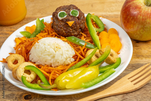 Food ideas for kids. Plate of fresh vegetables, meat balls in the form of chick, rice, mini bagels.
