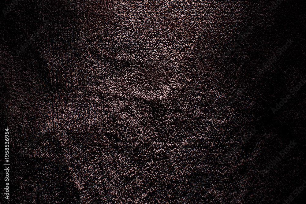 Fototapeta premium Macro shot of deep brown plush terry fabric showing detailed pile loops and dramatic lighting with moody shadows for an elegant background. 