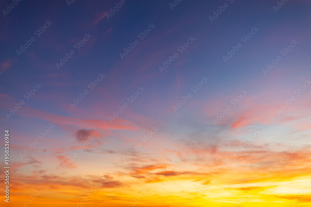 Fototapeta premium Vibrant sunset sky with orange and purple clouds background,Beautiful dramatic sunset sky with colorful clouds in shades of orange, pink, and deep blue. High resolution golden hour sky background for 