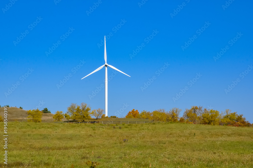 Fototapeta premium Wind turbine in the field in a sunny day
