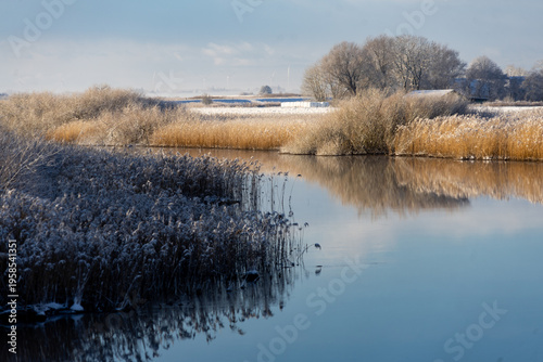 Golden hour at Wadden Sea National Park: Misty winter sunrise over Danish marshland and river 