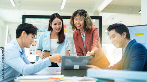 Smiling business people team working in office.Group of young asian business people brainstorming roadmap,planning and strategy in modern office.Teamwork is about achieving greatness together.