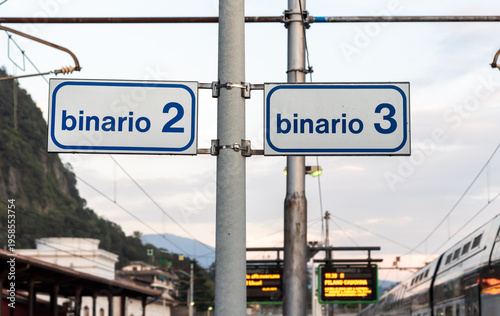 Wallpaper Mural Signage indicating platforms 2 and 3 at Laveno Mombello railway station, located in the province of Varese, Lombardy, Italy. Public transport infrastructure and travel concept. Torontodigital.ca