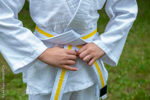 Photography white-yellow belt, child athlete in judo uniform, dedication and strength in mar