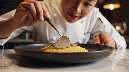 Chef Expertly Garnishes Exquisite Risotto Dish with Fresh Truffle Slices.