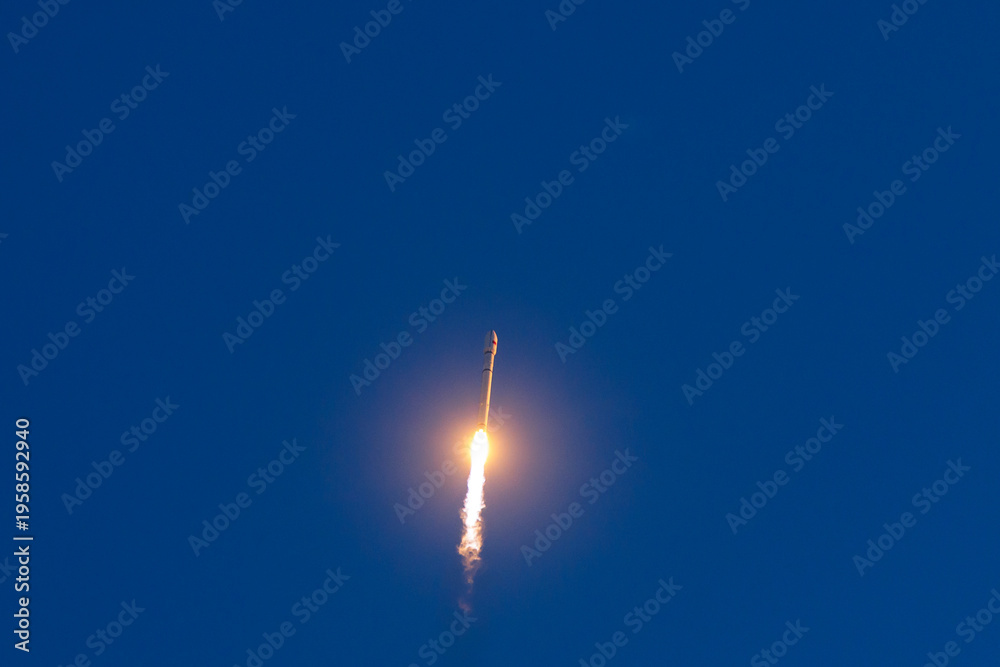 Fototapeta premium Space rocket with satellites launching against clear blue sky with trail of flame, aerospace program of China.