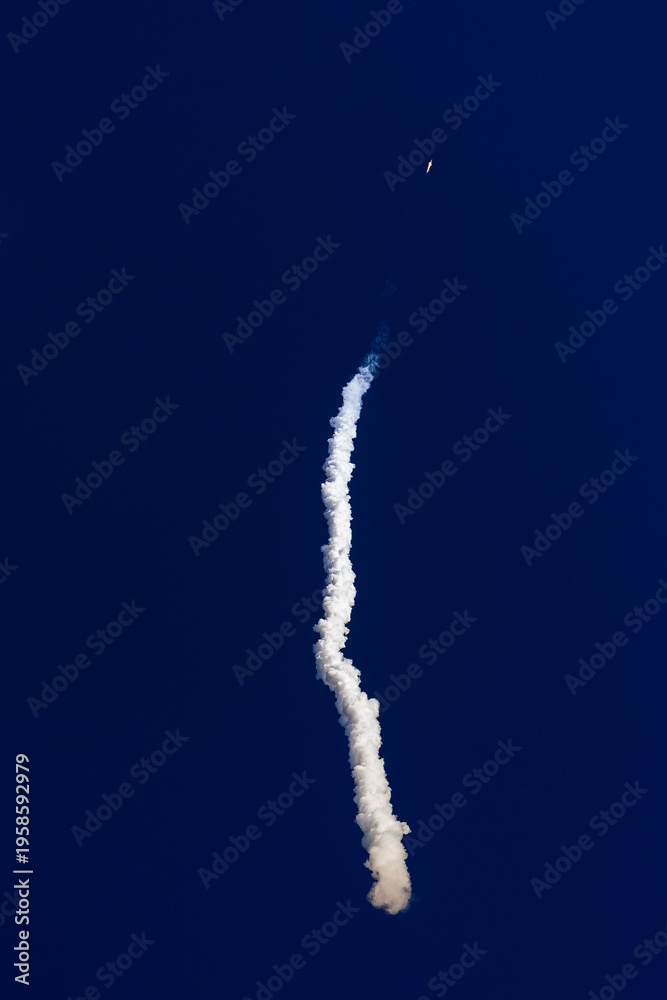 Fototapeta premium Rocket with satellites launch with smoke trail against deep blue sky