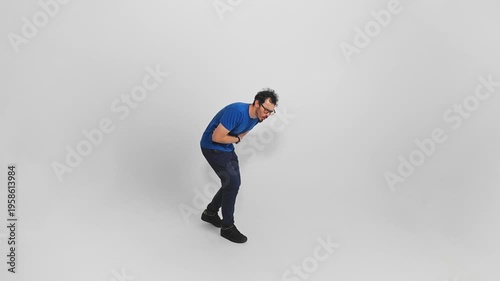 Man holding his stomach with one hand is suffering from abdominal pain and discomfort filmed in slow motion on white background. Isolated of Caucasian male person having intoxication and feeling sick.
