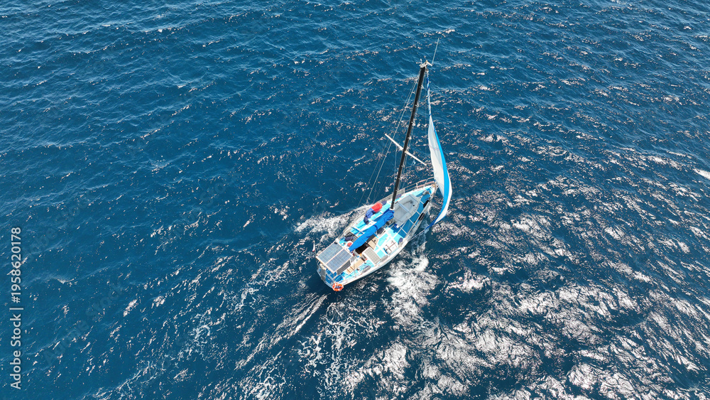 Obraz premium Aerial drone photo of small sail boat cruising deep blue Mediterranean Sea