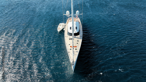 Aerial drone photo of beautiful luxury sail boat with wooden deck anchored in deep blue Mediterranean sea 