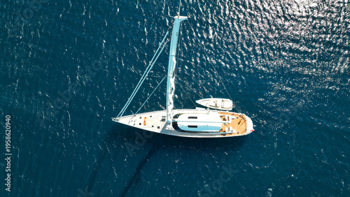 Aerial drone photo of beautiful luxury sail boat with wooden deck anchored in deep blue Mediterranean sea 