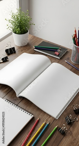 Open blank magazine and notebook on a wooden desk with pencils, office supplies, and a plant, perfect for design, study, or mockups
