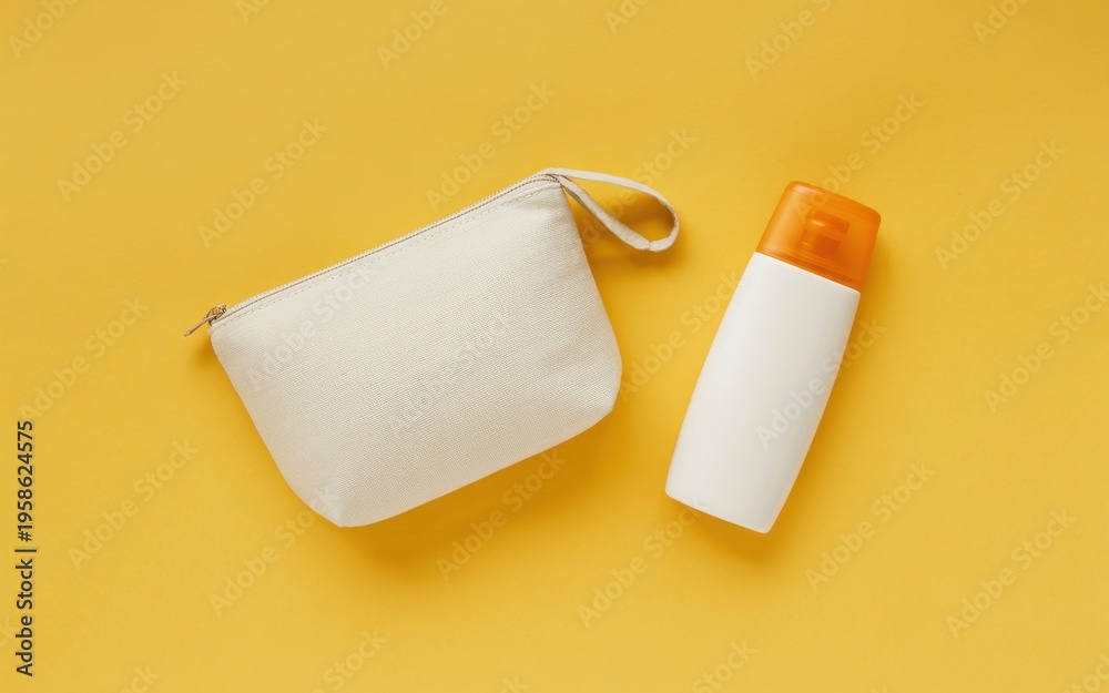 Obraz premium A white cosmetic pouch and sunscreen bottle on a yellow surface