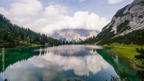 Seebensee Lake Timelapse with Zugspitze Mountain Reflection; Scenic Austrian Alps Landscape in Tyrol featuring Turquoise Water Moving Clouds and Alpine Peaks at Summer Establishing Shot