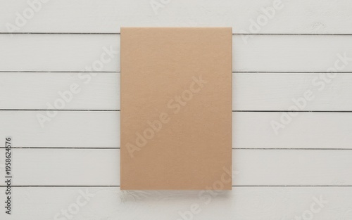 A brown cardboard box sits on white horizontal slats