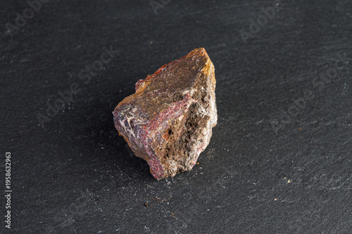 Fotografie Macro view of a rough, crystalline mineral specimen with reddish-purple veins on