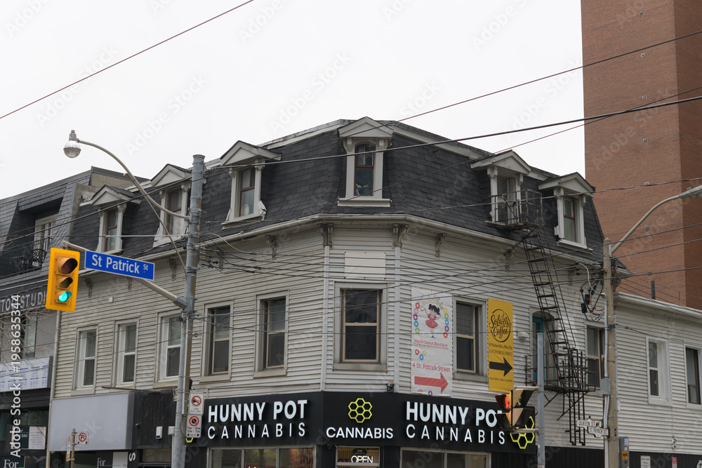 Fototapeta premium exterior of historic building and sign of Hunny Pot Cannabis located at 198 Queen St W, Toronto