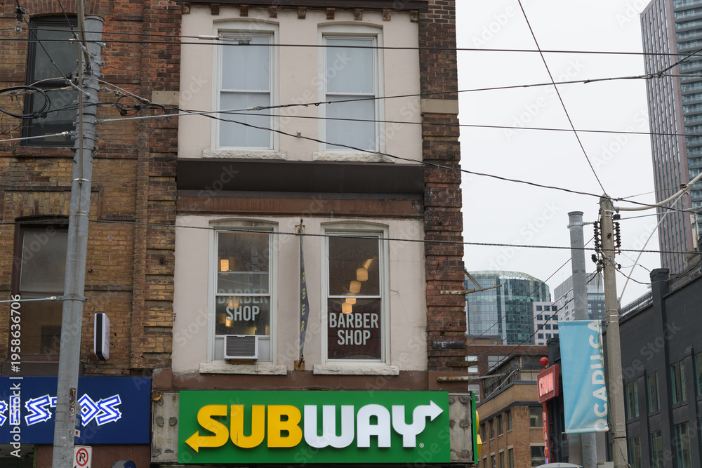 Obraz premium exterior building and sign of Subway, a sandwich shop chain, located here at 267 Queen St W, Toronto