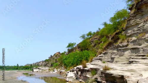 Rocky Hillside with Greenery and Clear Blue Sky