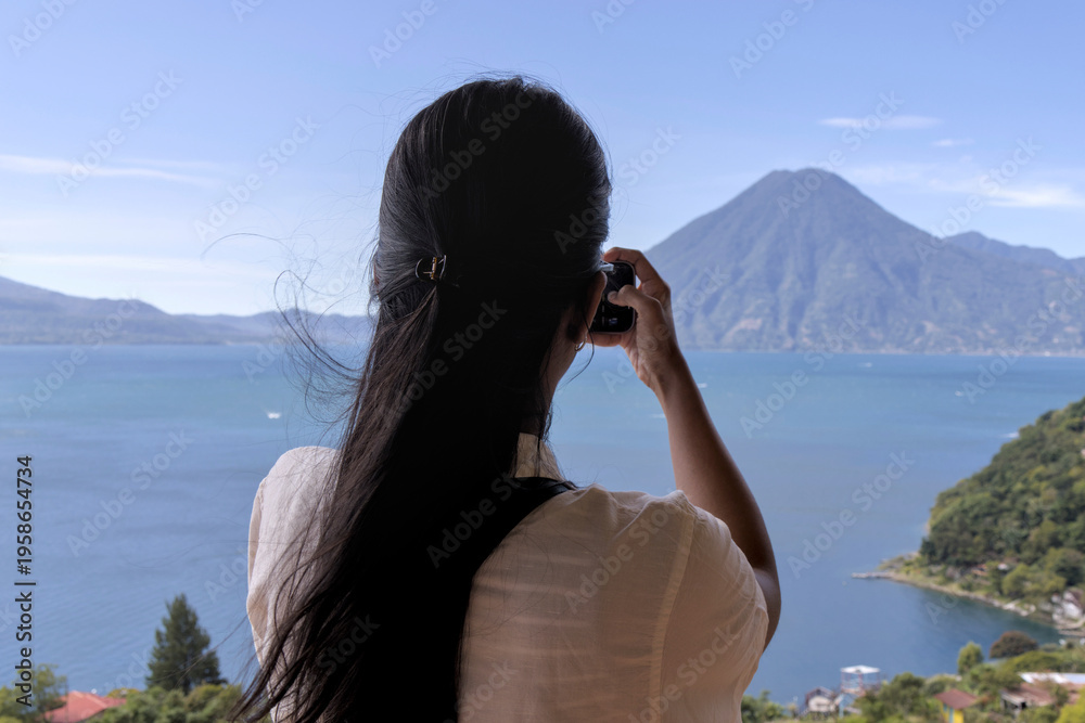 custom made wallpaper toronto digitalWoman taking a photo of volcanos and mountains at lake atitlan from a restaurant patio. travel, exploration, and nature appreciation