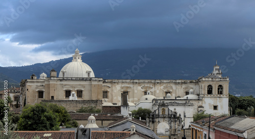 Wallpaper Mural Wide view of rooftops, streets, and distant church dome under a dramatic sky, antigua guatemala historic urban landscape. Torontodigital.ca