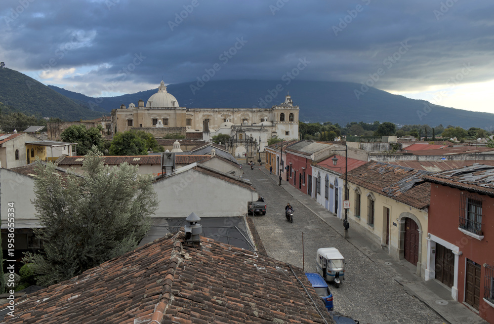 custom made wallpaper toronto digitalWide view of rooftops, streets, and distant church dome under a dramatic sky, antigua guatemala historic urban landscape.