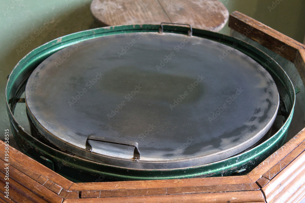 custom made wallpaper toronto digitalClose-up of a traditional flat cooking griddle in a rustic kitchen setting, representing authentic local cuisine preparation and cultural heritage in a Central American home.