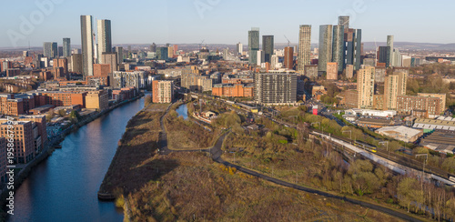 Aerial panorama over Pomona Island featuring River Irwell, Metrolink tram tracks, and the expanding skyscraper cluster in Manchester, UK.